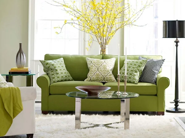 kleines wohnzimmer grünes sofa weißer teppich glastisch