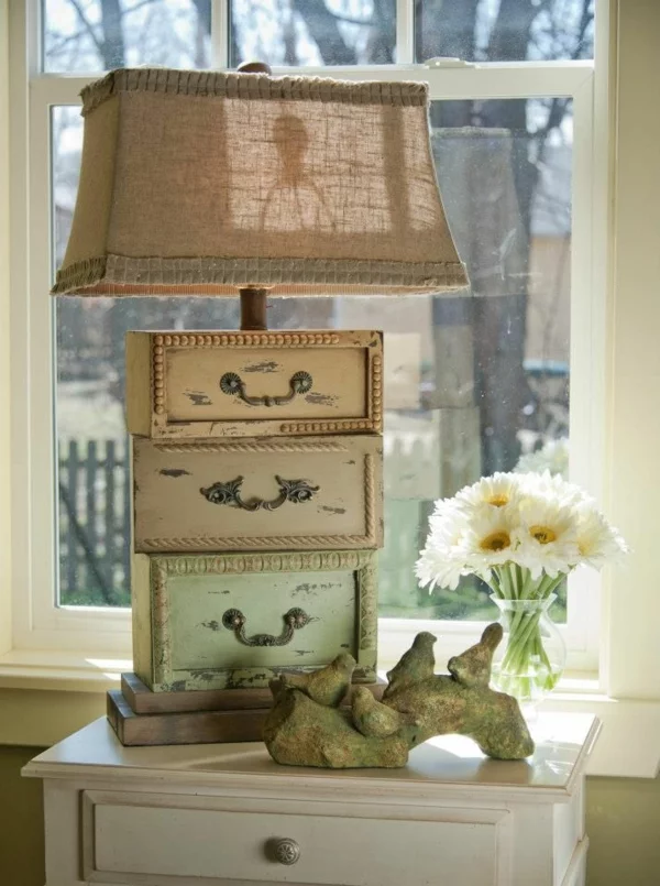 alte Möbel neu gestalten Tischlampe aus alten Schubladen Lampenschirm aus Leinen Vase mit weißen Margeriten 