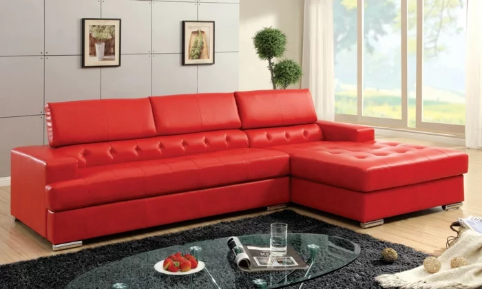rote sofas wohnzimmer grauer teppich gläserner ovaler couchtisch