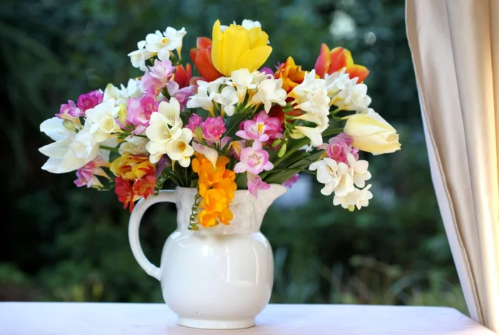 gartenpflanze freesien blumenstrauß weiße vase