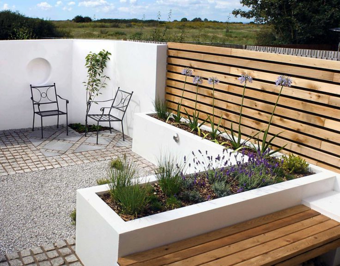 moderne terrassengestaltung weiße wand kieselsteine pflanzen
