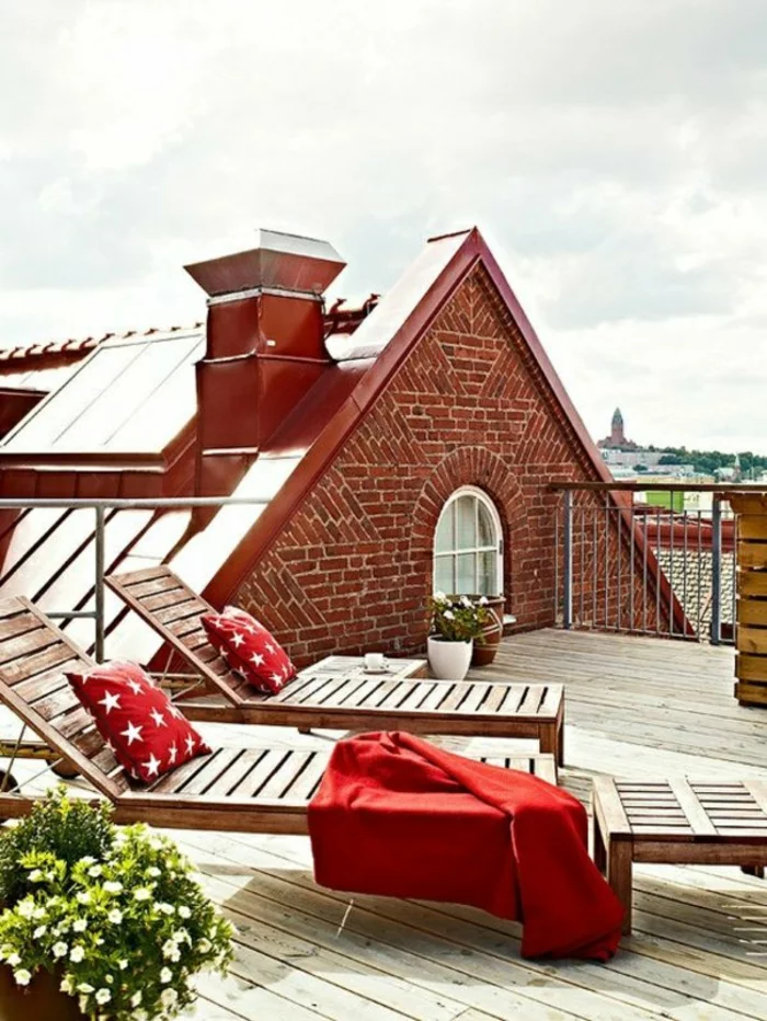 romantischen Ort auf der Dachterrasse gestalten mit Holzliegen und roten Kissen tolle Terrassen Ideen