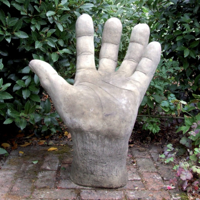 gartenskulpturen stein riesige hand garten pflanzen