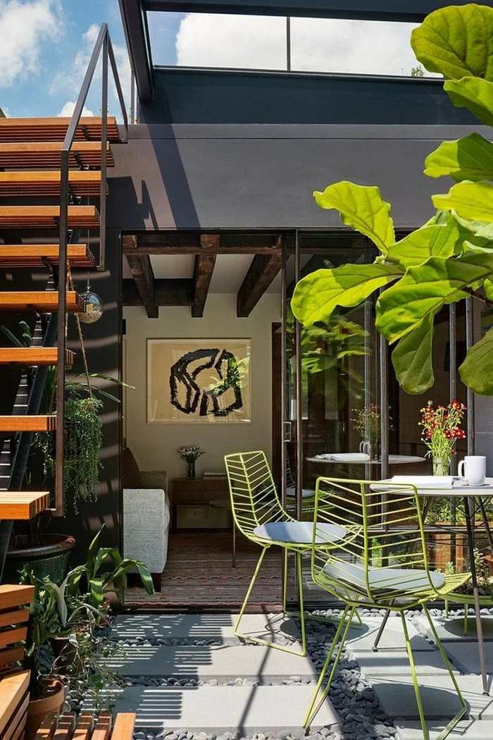Terrasse modern gestalten mit grünen Gartenstühlen, Bodenplatten und Kies
