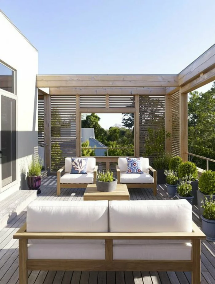 moderne Holzterrasse Ideen mit grünen Balkonpflanzen und weißen Polstermöbeln für draußen 