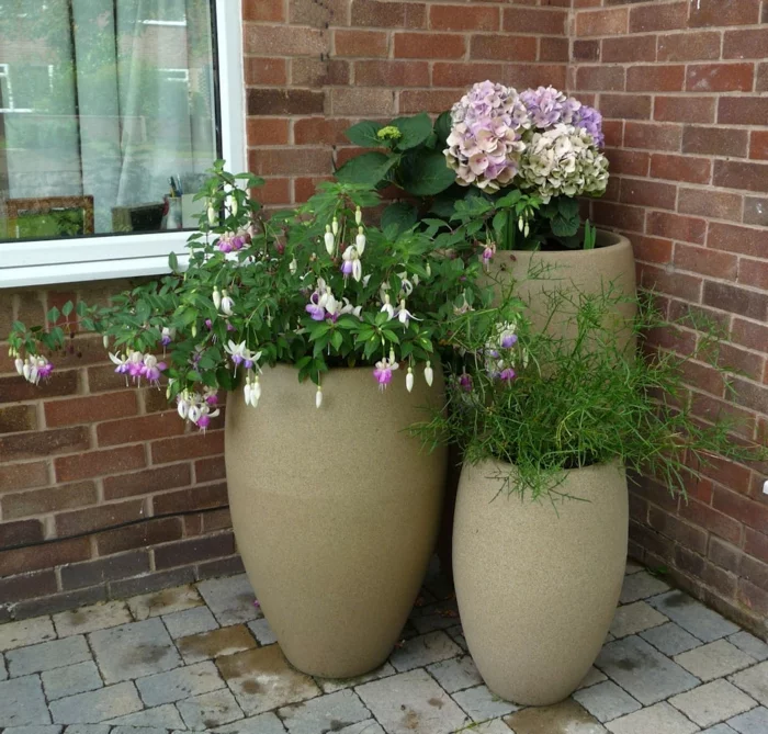 moderne Pflanzkübel mit blühenden Pflanzen für den Außenbereich