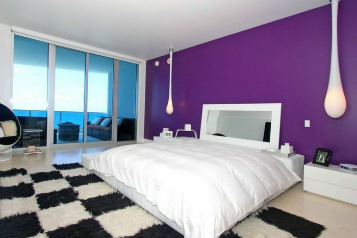 schlafzimmer einrichten coole hängeleuchten teppichmuster schwarz weiß lila akzentwand