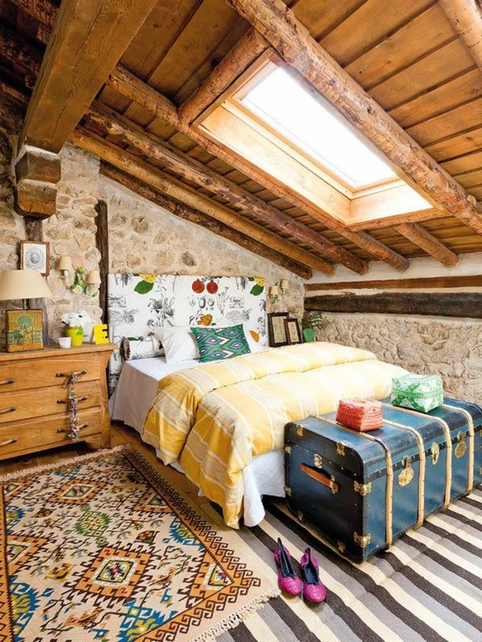 schlafzimmergestaltung dachgeschoss offene deckenbalken rustikal ethno motive alte truhe