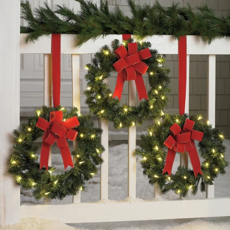 Weihnachtskranz selber basteln Fensterdeko drei Kränze rote Schleifen Lichter 