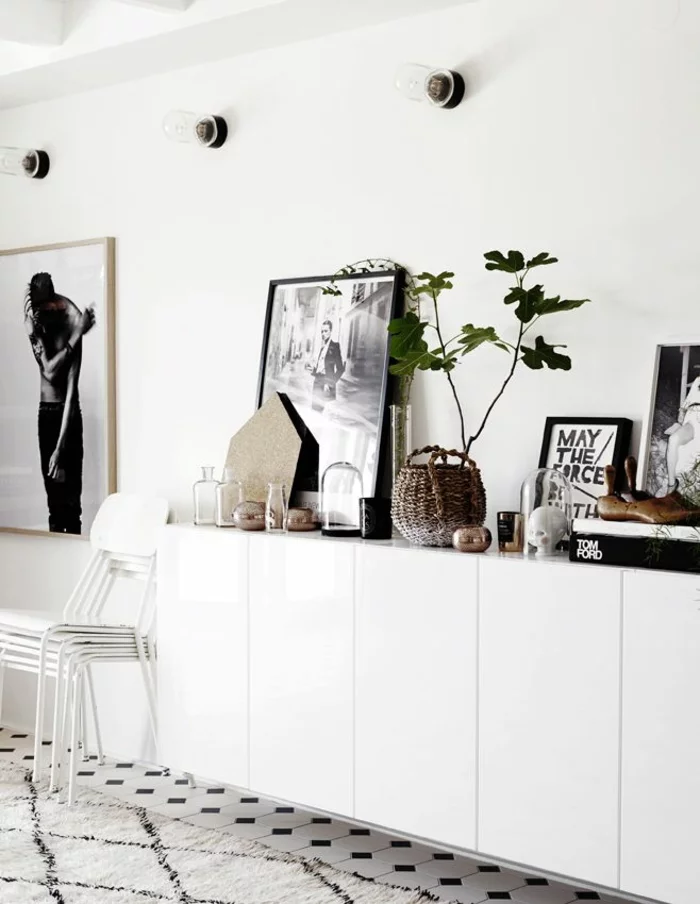 lange, weiße Anrichte mit glatten Fronten, dekoriert mit Korb, Zimmerpflanze, Bilder, Fotos und gläsernen Behältern 