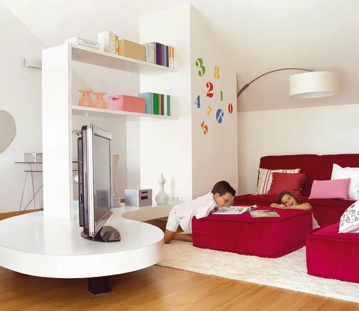 geräumiges Kinderzimmer mit zwei roten Betten und weißem Regal mit Auflage