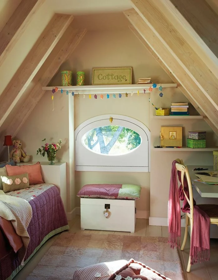 kleines Kinderzimmer mit Satteldach, einem Bett, Truhe, ovalem Fenster und Schreibtisch eingerichtet