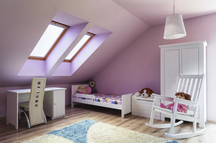 kleines Kinderzimmer mit Dachschräge, zwei Dachfenstern und lilafarbenen Wänden