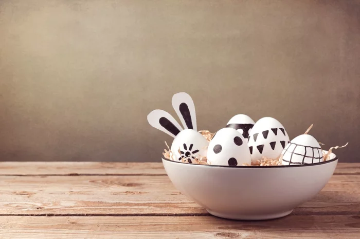 Osterdeko in der Schale mit grafisch gestalteten Eiern