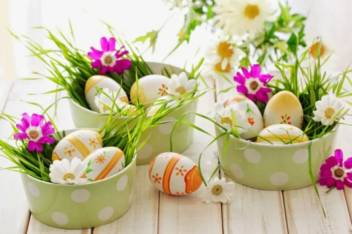 Osterkörbchen aus Porzellan voller Ostereier und Frühlingsblumen 