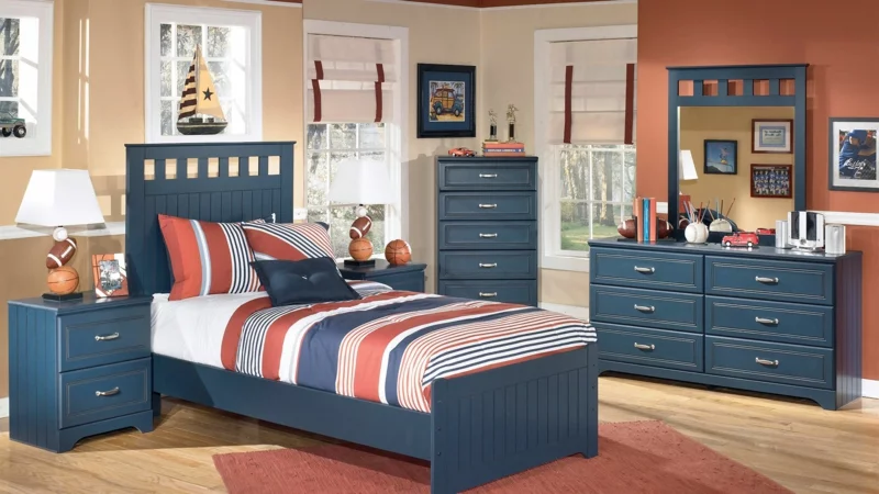 klassische Raumgestaltung im Kinderzimmer für Jungs dunkelblaue Möbel gestreifte Bettwäsche 