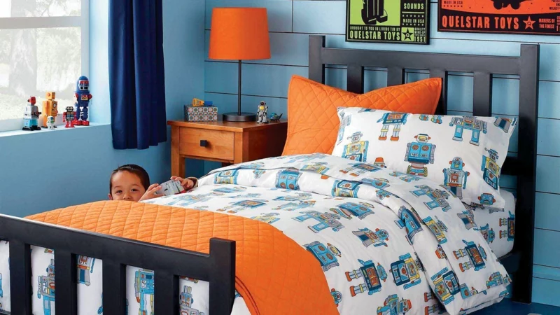 gemütliches Kinderzimmer für Jungs praktische Kindermöbel Wandfarbe Blau Kinderbettwäsche Orange