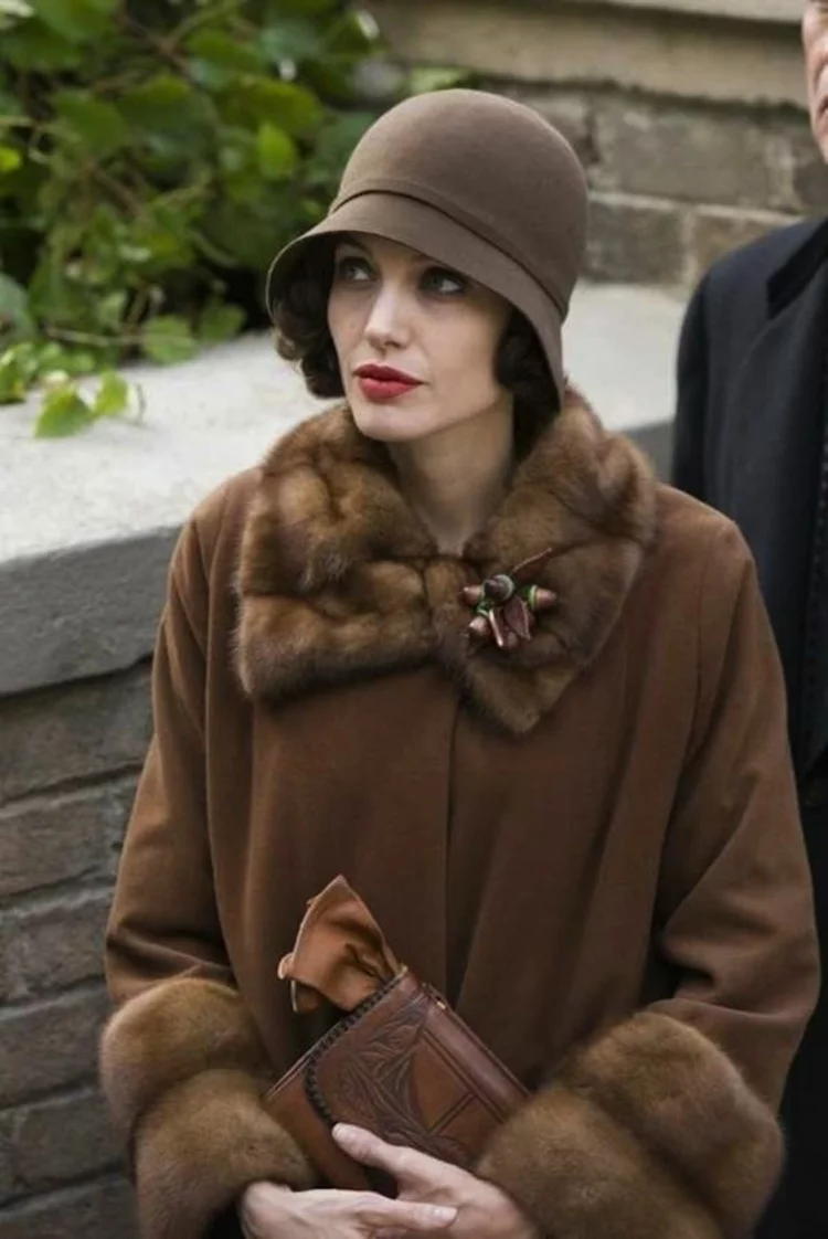 Retro Damenhüte Angelina Jolie im Stil der 20er Jahre gestylt brauner Mantel und passender Filzhut 