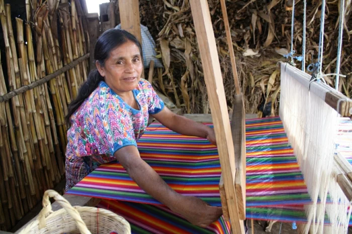 fairtrade produkte einkaufen textilien kooperative frau webt gestreifte stoffe