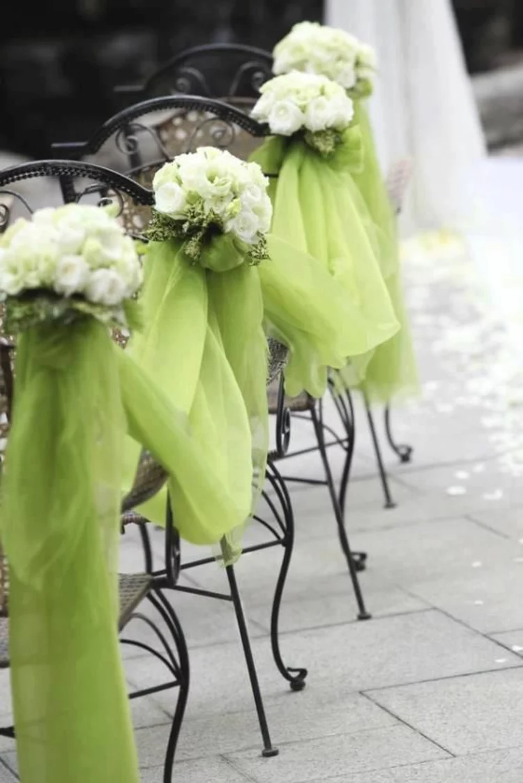Hochzeitsfeier Ideen grüner Organzastoff und Blumen Stühle dekorieren