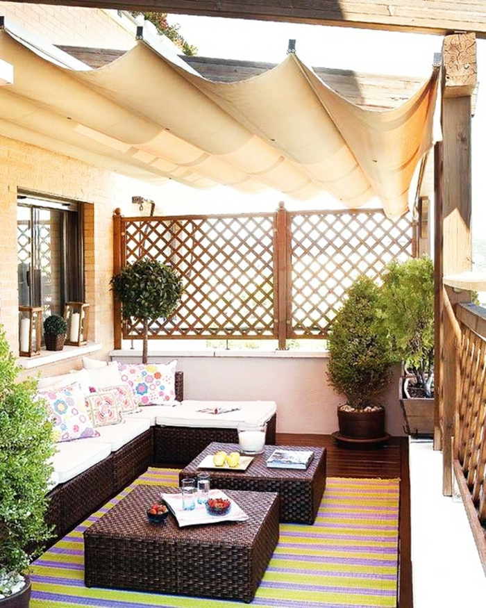 rattanmöbel ottomane sofa kissen balkonpflanzen teppich sonnensegel