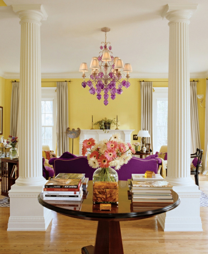 farbgestaltung wohnzimmer gestalten gelbe wände weiße säulen violettes sofa