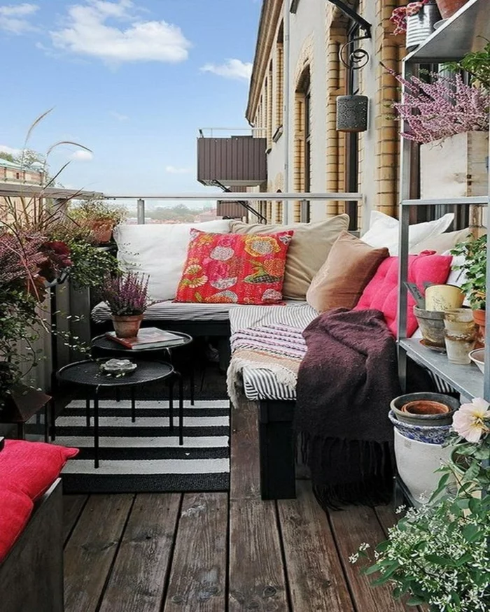 holzdielen-balkonmöbel-bunttextilien kisssen runde beistelltische teppichläufer schwarz weiß streifen balkonpflanzen