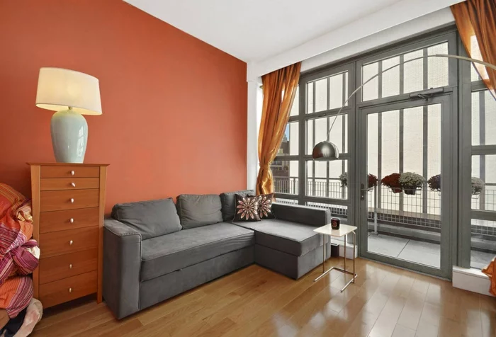 innendesign wohnideen wohnzimmer graues ecksofa orange akzentwand