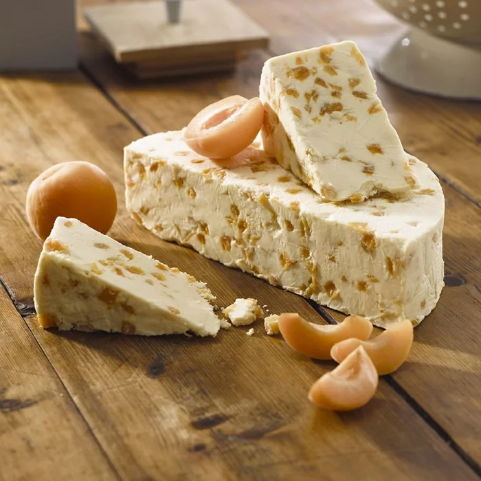 Käsesorten - Stilton-Schimmelkäse und Aprikosen-Stücke auf dem Esstisch