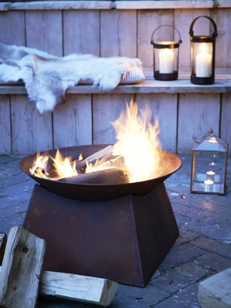 Feuerschalen Grillen im Garten Sommerhaus abends Kerzen anzünden Fell Brennholz
