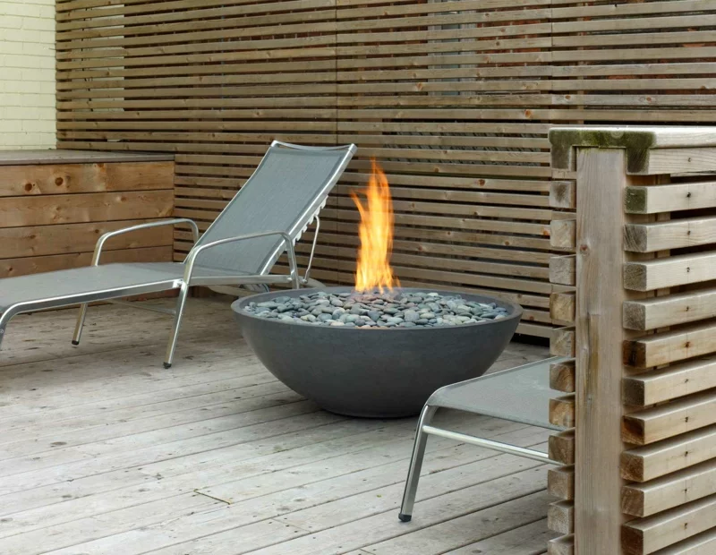 Feuerschalen mit Kieselsteinen loderndes Feuer Liegestuhl Relax im Garten 