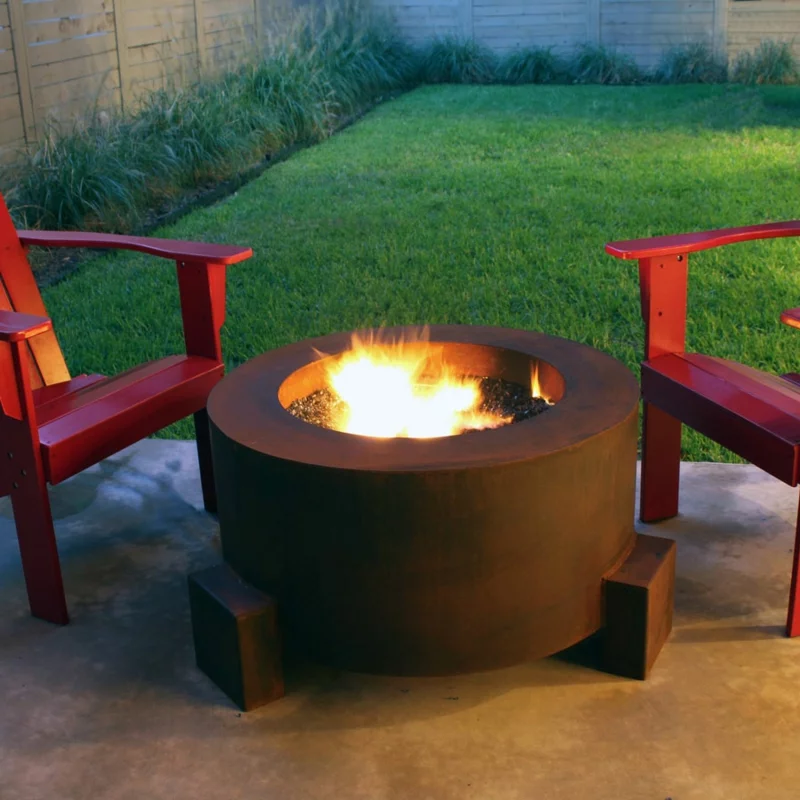 Feuerstelle bauen Feuerschale im Garten zwei rote Holzstühle Gemütlichkeit zu zweit