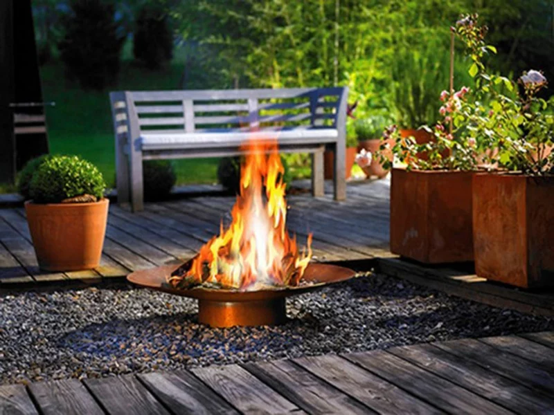 Feuerstelle bauen Gartengestaltung Feuerschale aus metall grüne Pflanzen in Kübeln