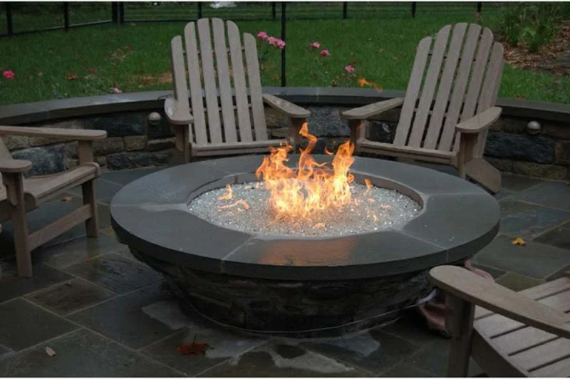 Feuerstelle bauen Gartengestaltung mit Steinen alles in Grau stilvoller Look Holzstühle Bodenbelag Steinplatten