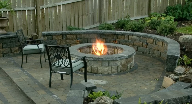 Feuerstelle bauen Steine und Kies Gartengestaltung mit Steinen Steinmauer zwei Stühle aus Metall 