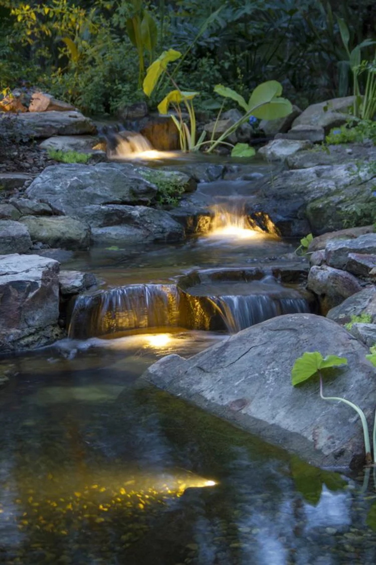 Gartenteich Bilder eingebaute Gartenbeleuchtung Wasserpflanzen große Steine 