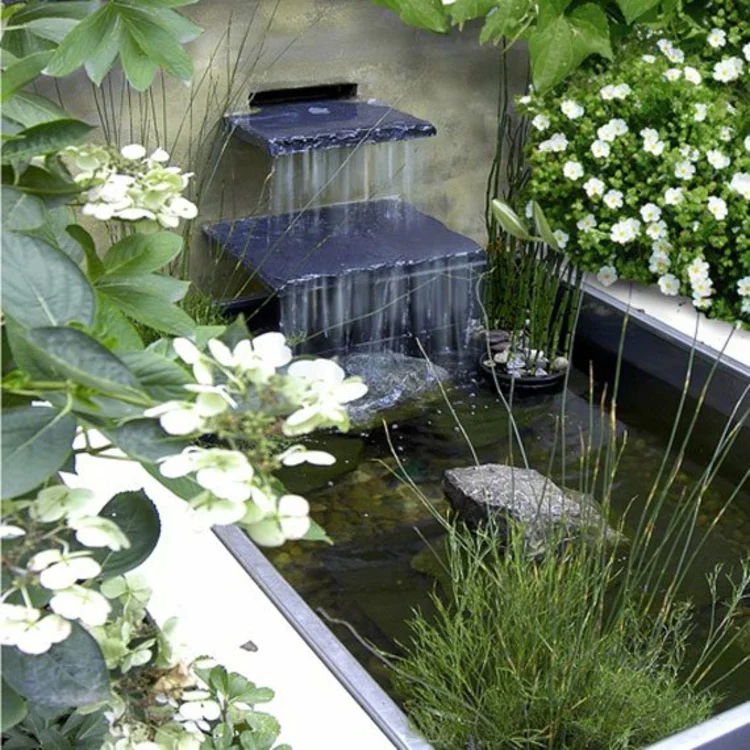 Gartenteich Bilder japanischer Garten Ideen Wasserquelle Garten Steinwand weiße Blüten 