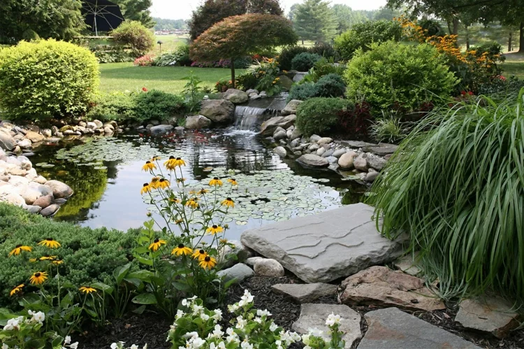 natürliche Gartenteich Bilder kreative Gartengestaltung Wasserpflanzen große Steine 