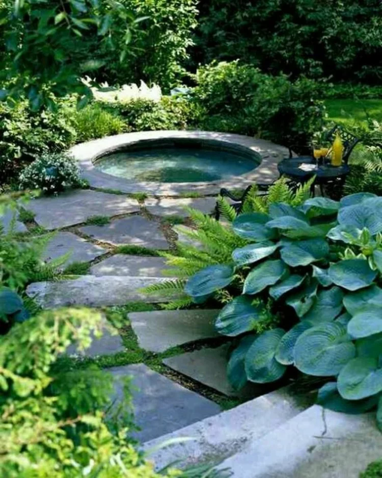 Gartenteich Bilder runder Teich große Steinplatten viel üppiges Grün eine Oase der Ruhe 