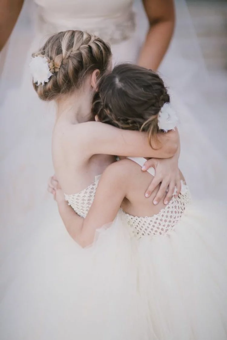 Kommunionfrisuren für Mädchen festliche Frisuren mit kleinen Haaraccessoires geschmückt zwei kleine Mädchen mit weißen Blumen im Haar