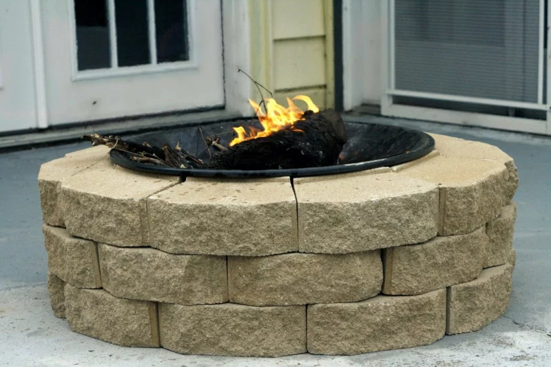 Stein Feuerstelle bauen Gartengestaltung mit Steinpflastern runde Form loderndes Feuer 