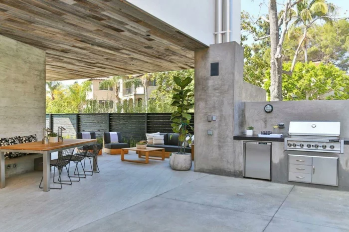 außenküche selber bauen terrasse überdachung betonwände industrieller stil esstisch eingebaute küchengeräte
