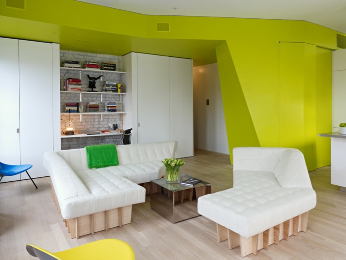 einzimmerwohnung einrichten loftwohnung wohnzimmer sofa couch weiß holzmöbel neongrüne wände