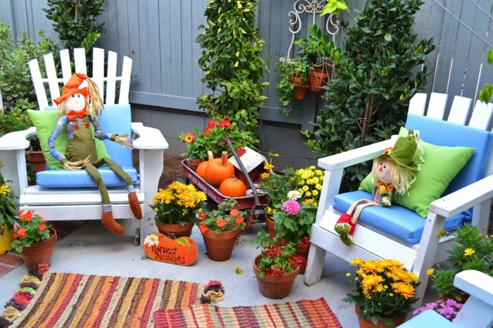 lustige Gartengestaltung für den Herbst mit Strohmännern und Kürbissen