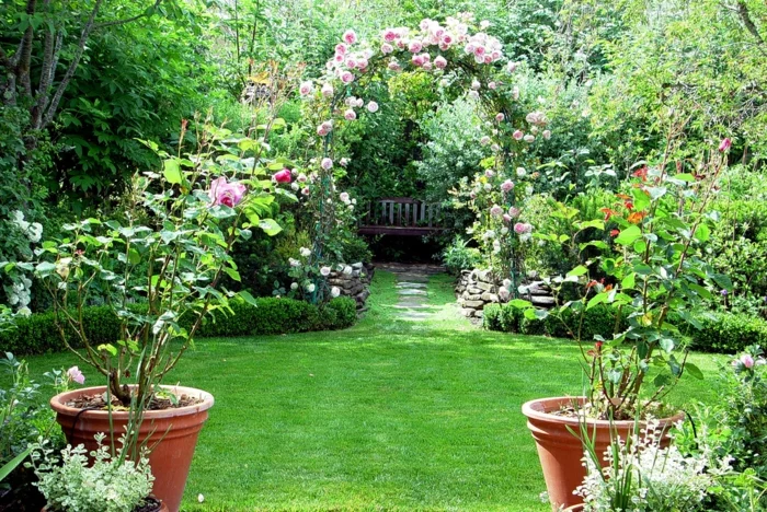 symmetrische Gartengestaltung mit Gartenbogen und grünem Rasen