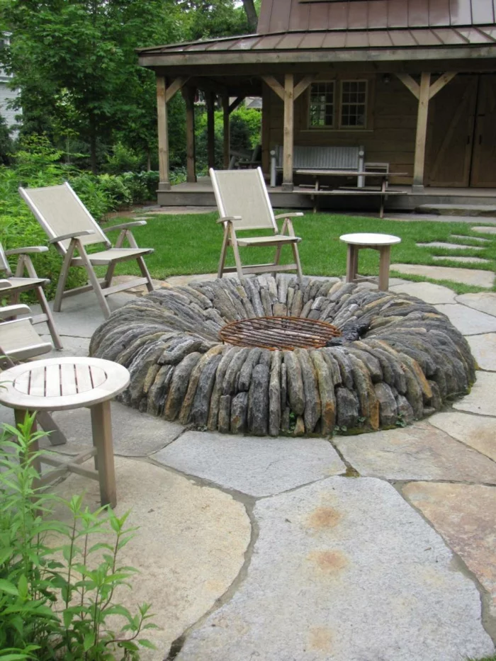 Gartengestaltung mit Steinplatten als Bodenbelag und Feuerstelle