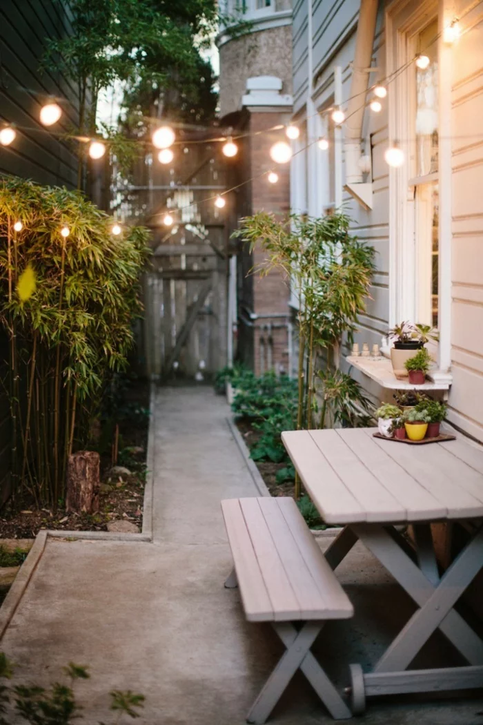 Gartengestaltung mit Lichterketten und Holzmöbeln für die Terrasse