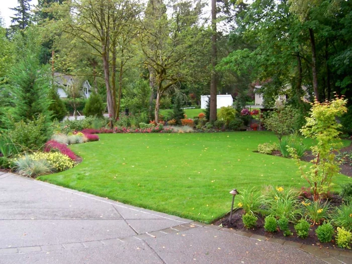 großer Hinterhof mit grünem Rasen und Blumenbeeten