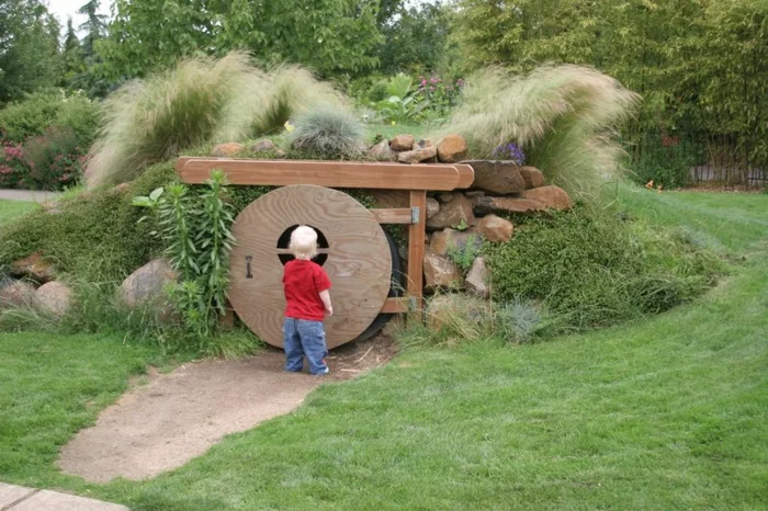 kleiner Junge vor einem DIY Hobbit Gartenhaus 