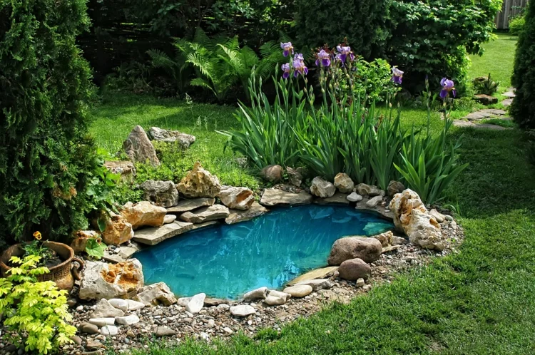 inspirierende Gartenteich Bilder Gartenideen Wasserquelle im Garten geformt aus Steinen schöne Blumen und viel Grün 